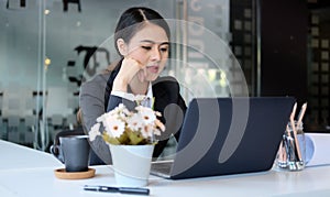 Concentrated businesswoman analysing financial data on computer laptop