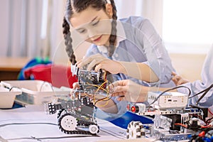 Concentrated caucasian girl creating technical toy photo