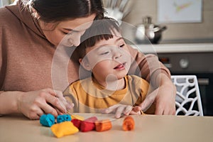 Concentrated caucasian woman playing with her son at the kitche