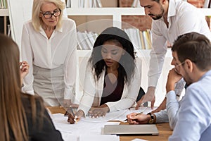 Concentrated colleagues brainstorm discussing paperwork at briefing