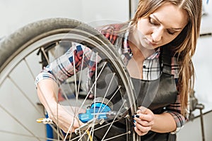 Concentrated craftswoman measuring the pressure of a tire
