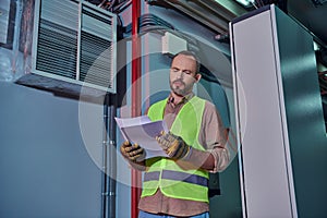 concentrated devoted technician in safety vest