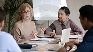 Concentrated diverse colleagues discuss business ideas at office meeting