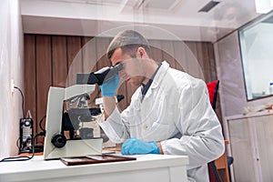Concentrated doctor using microscope to analysis samples in a laboratory