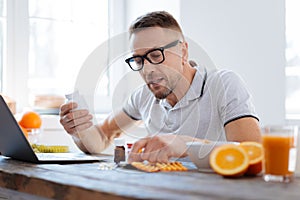 Concentrated earnest man taking biohacking supplements