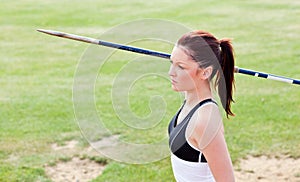 Concentrated female athlete ready to throw javelin