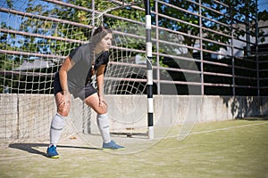 Concentrated female goalkeeper standing in goals