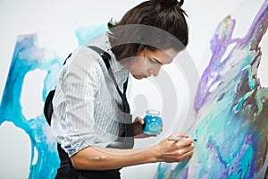 Concentrated girl focused on creative art-making process in art therapy