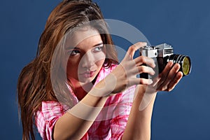 Concentrated girl holds old camera