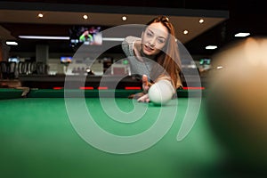 Concentrated girl while playing billiards