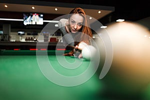 Concentrated girl while playing billiards