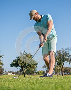 concentrated golfer in cap with golf club, golfing