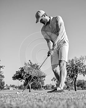 concentrated golfer in cap with golf club, golfing