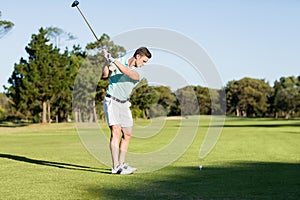 Concentrated golfer man taking shot