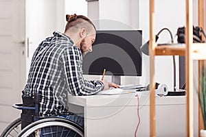 Concentrated handicapped man making notes