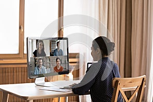 Concentrated happy young Indian female employee holding video call.