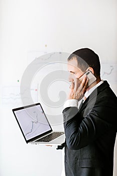concentrated investment manager talking on phone and drinks coffee