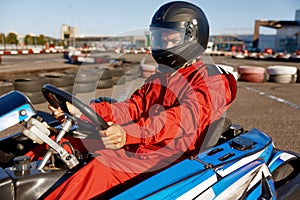Concentrated karting pilot ready to start championship in outdoor go-karting circuit