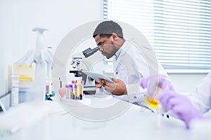 Concentrated lab technician using microscope