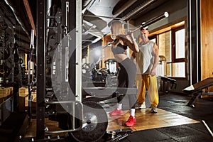 Concentrated lady doing a set of weight-lifting exercises