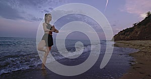 Concentrated lady practicing yoga in the middle of beach side take the meditation poses standing up and enjoying the