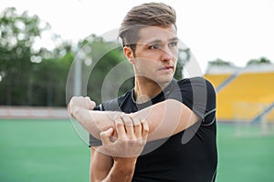 Concentrated male athlete make stretching exercises outdoors