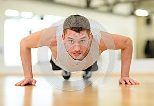 Concentrated man doing push-ups in the gym