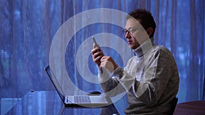 Concentrated man freelancer in eyeglasses working remotely at home.