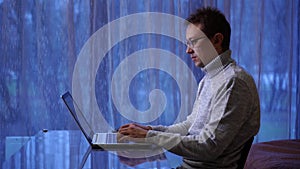 Concentrated man freelancer in eyeglasses working remotely at home