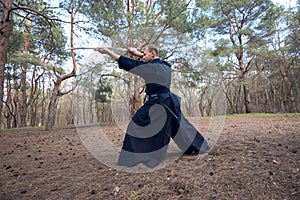 Concentrated man with a Japanese sword, a katana. Wide angle