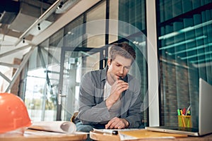 Concentrated man pondering on construction plan indoors