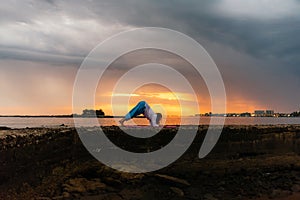 Concentrated Man Practicing Yoga in sunset