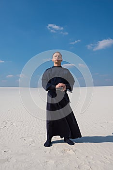 Concentrated man in traditional Japanese clothes stands and meditates