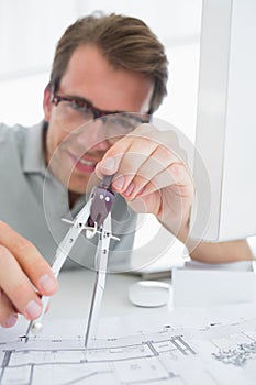 Concentrated man using compass on design