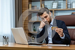 Concentrated mature businessman in suit analyzing finances in home office