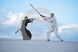 Concentrated men, in Japanese clothes, are practicing martial arts