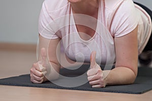 Concentrated Middle aged woman standing in plank position