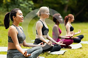 Koncentrovaný nadnárodní dámy meditace nebo dělat dýchání cvičení na jóga praxe mimo prázdný prostor 