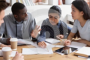 Focused diverse students discuss ideas studying in class together photo