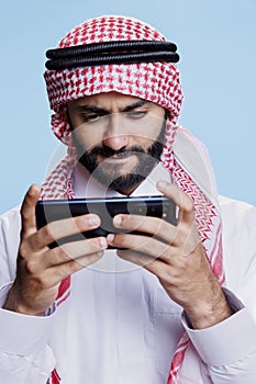 Concentrated muslim man playing game