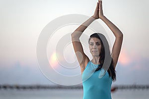 Concentrated person doing yoga and meditating on the shores of the riviera maya beach at sunrise in a relaxing