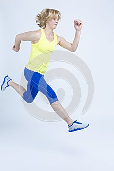 Concentrated Professional Mature Running Sportswoman in Jogging Outfit in High Jump