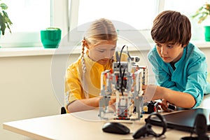 Concentrated pupils building a construction set robot.