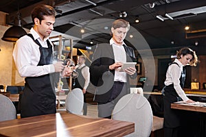 Concentrated restaurant manager checking online records on table