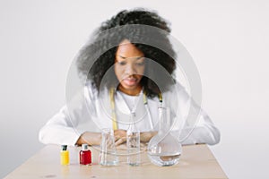 Concentrated scientist doing scientific experiment in laboratory. Portrait of a young beautiful African American girl
