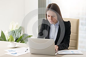 Concentrated serious businesswoman making report, working with l