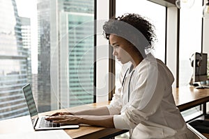 Concentrated smart young african businesswoman working on computer.