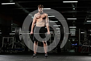 Concentrated strong sports man make sport exercises with barbell
