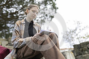 Young woman writing outdoors in urban setting