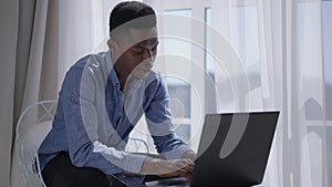 Concentrated successful businessman checking e-mail typing on laptop keyboard sitting in comfortable home office